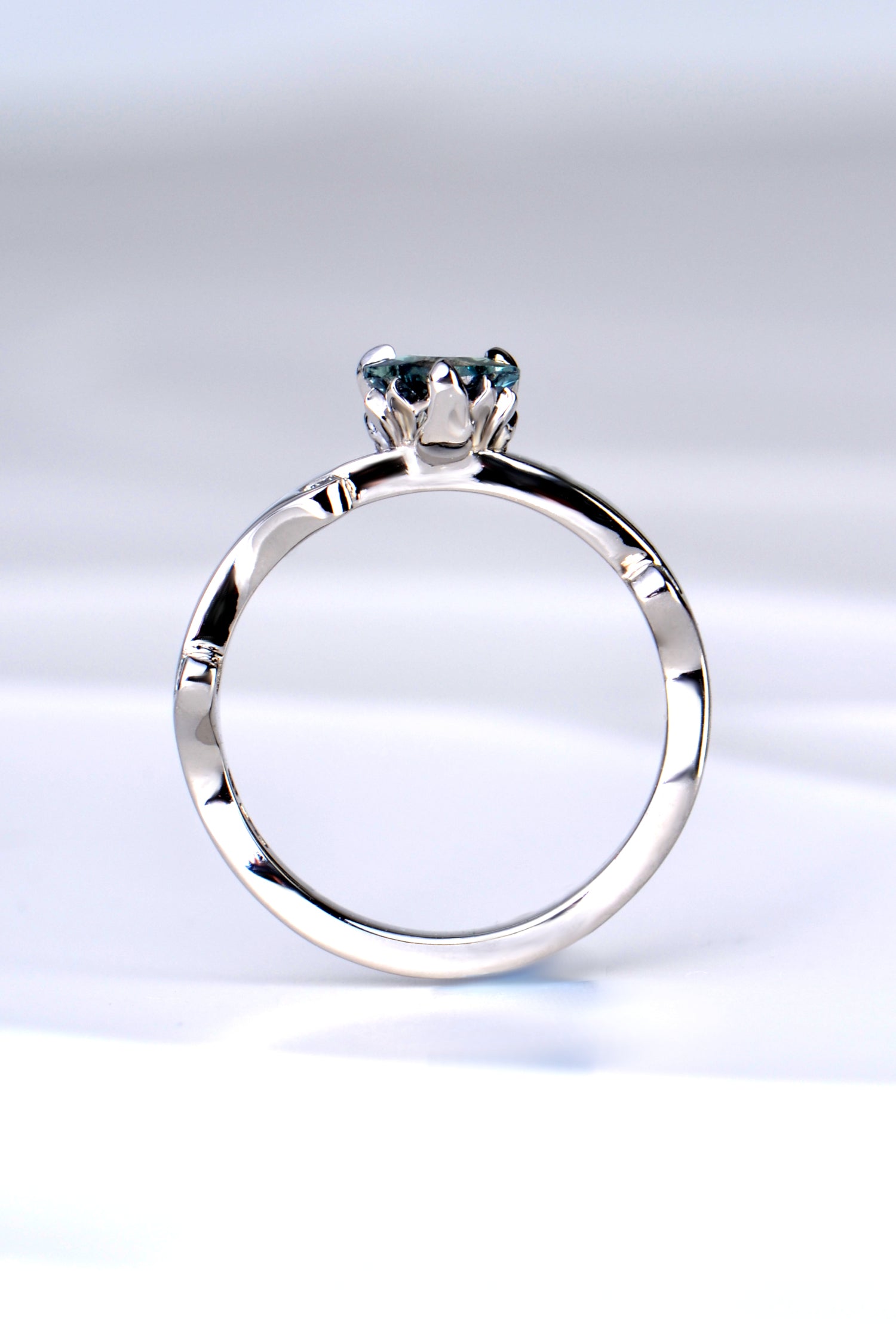 side view of the platinum and diamond heart cut Alexandrite colour change ring showing the sculptural design of the tiny flames that rise up to hold the gemstone