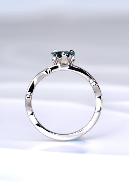 side view of the platinum and diamond heart cut Alexandrite colour change ring showing the sculptural design of the tiny flames that rise up to hold the gemstone