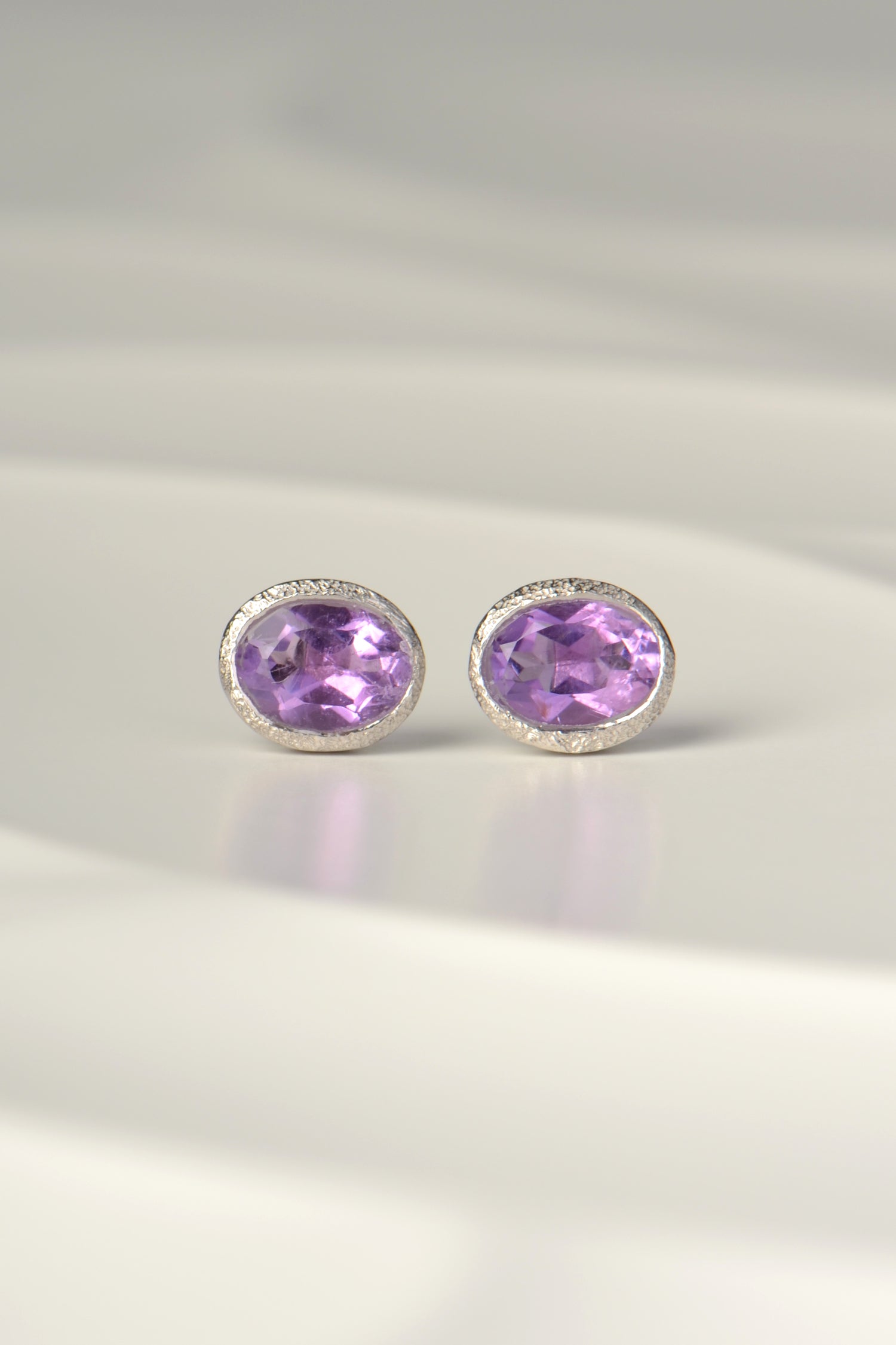Designer oval amethysts set in handmade silver stud earrings