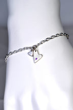 A modern sterling silver bracelet featuring two heart-shaped charms, one polished and one matte, hanging at the front of a polished silver link bracelet, with a round amethyst on the polished heart.