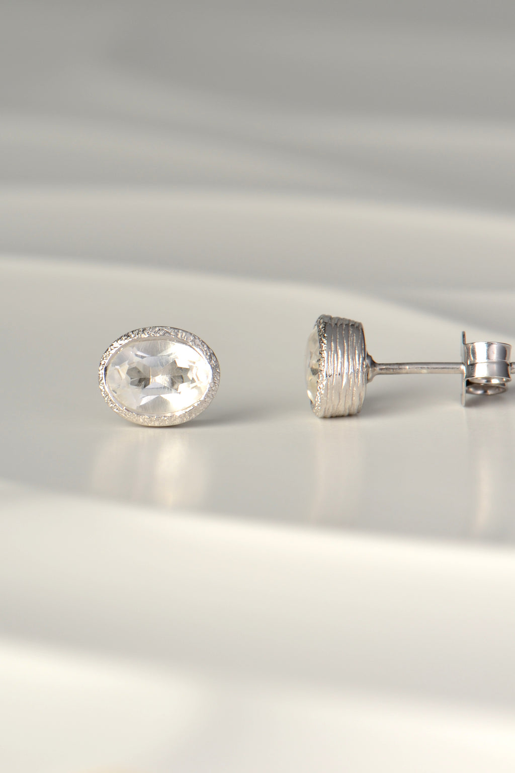 handmade silver earrings set with oval white topaz