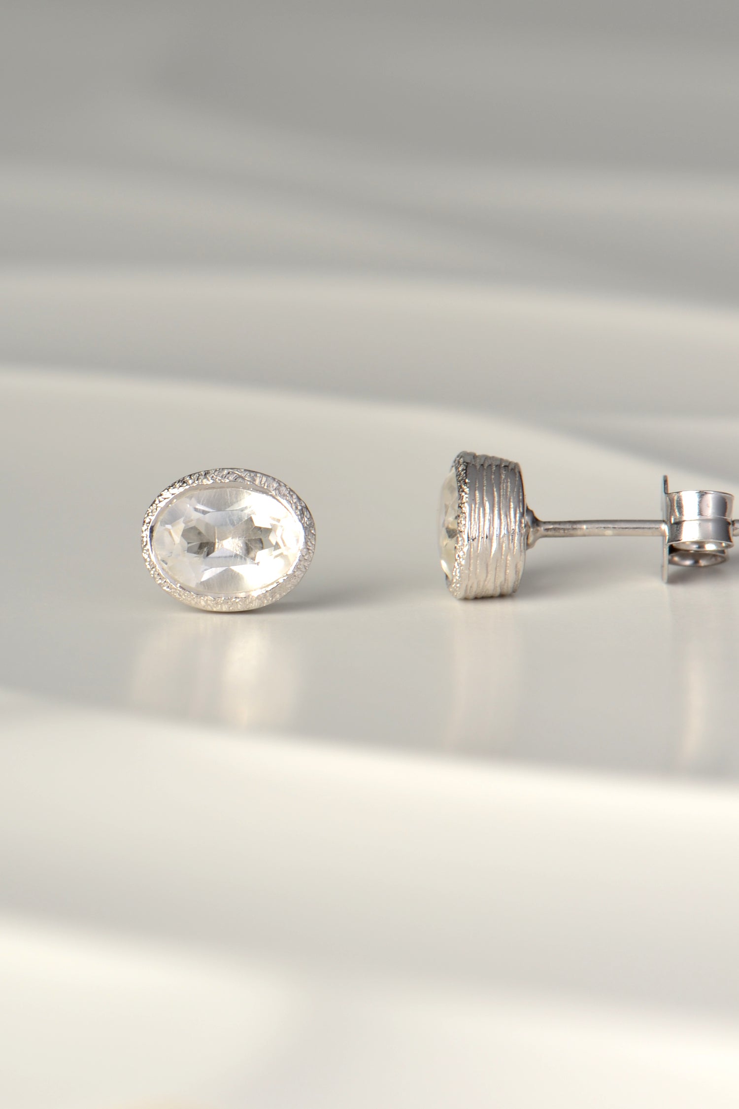 handmade silver earrings set with oval white topaz
