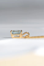 side view of 9ct yellow gold pendant set with a rectangular radiant cut aquamarine in a four claw setting with a double loop bail - Christine Sadler