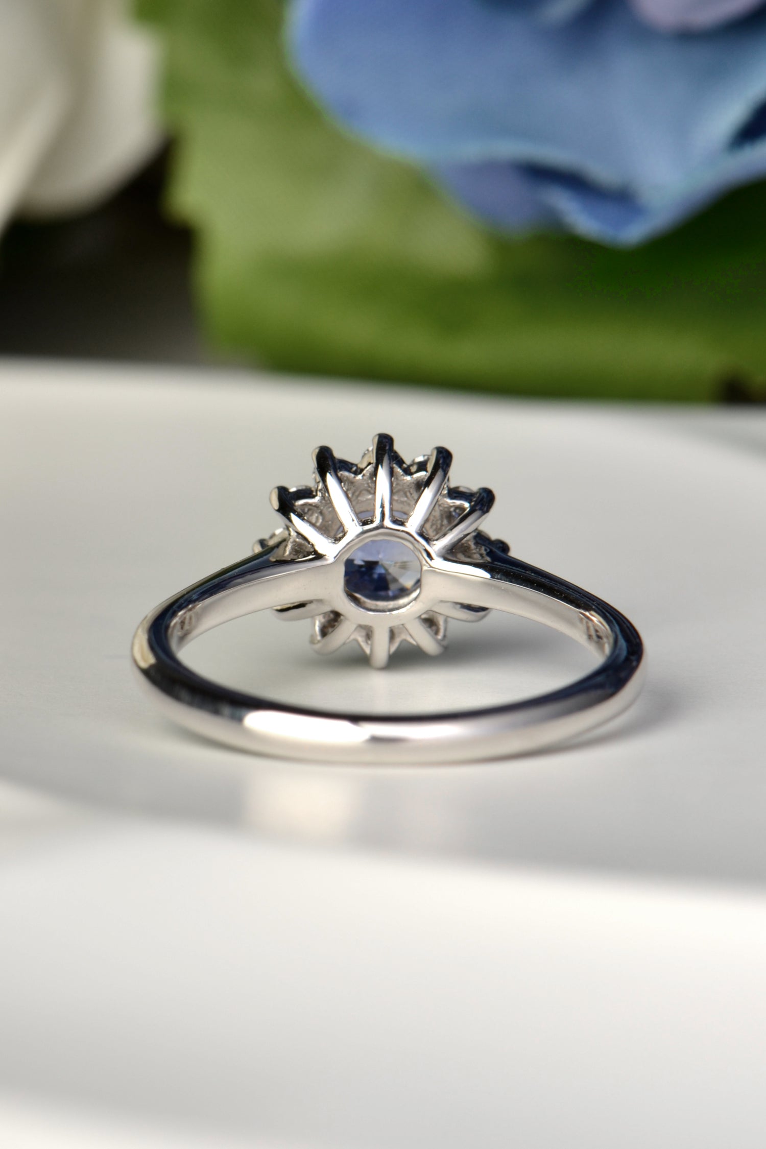Close-up of inside of the ring that has a one carat round sapphire surrounded by twelve brilliant cut diamonds