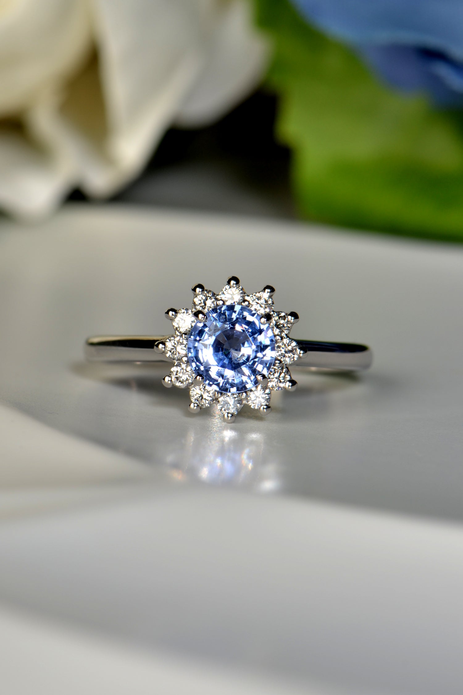 Platinum flower ring with round blue sapphire and twelve white diamonds
