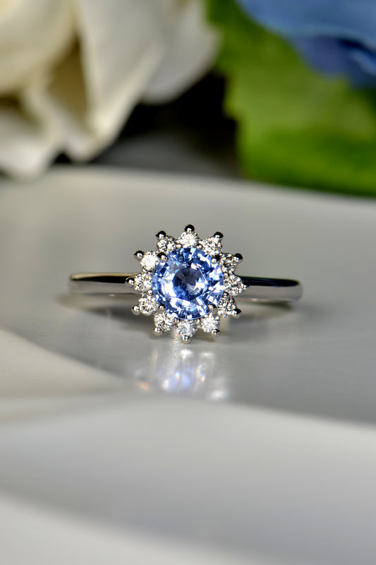 Platinum flower ring with round blue sapphire and twelve white diamonds