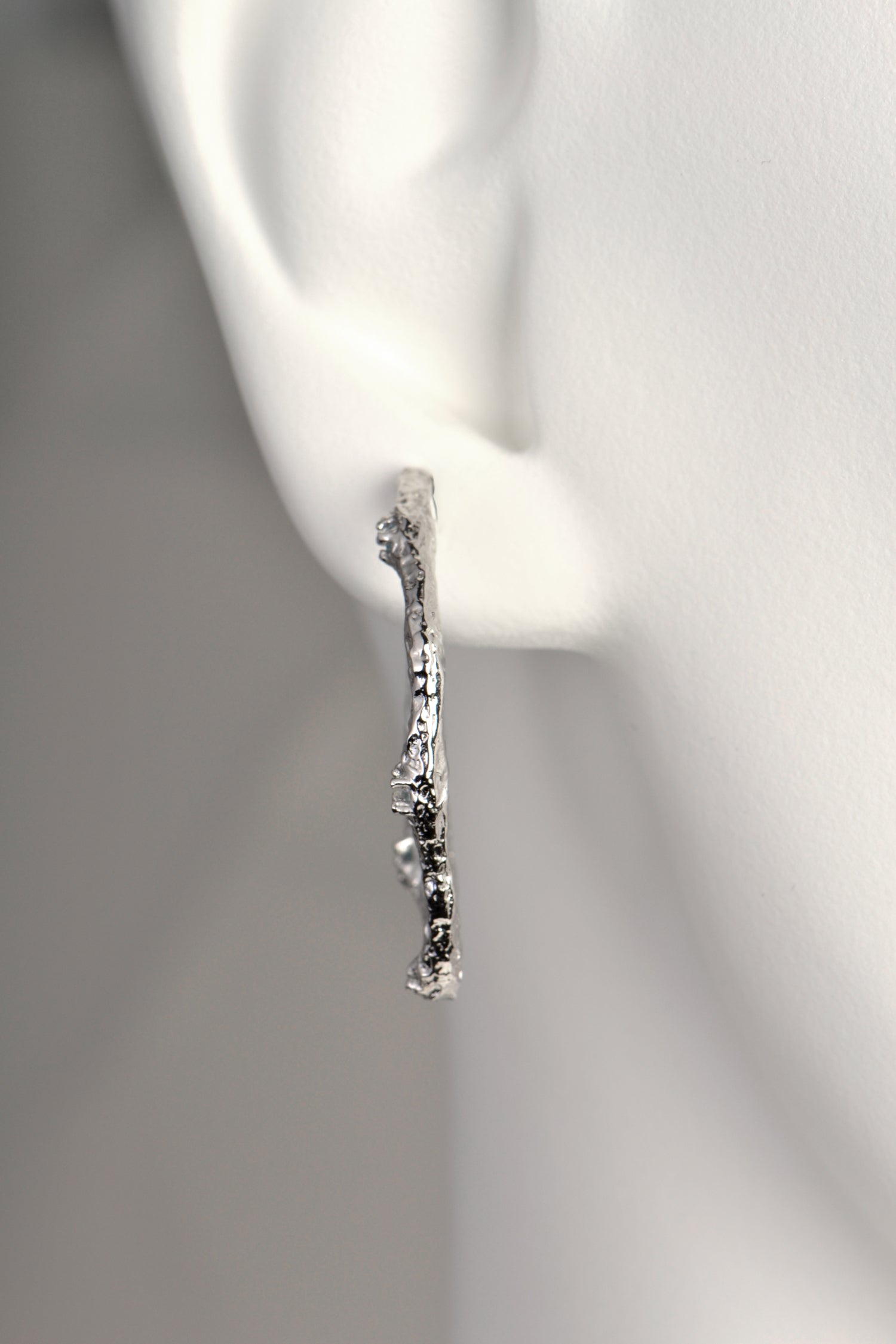 special and different large silver hoop earrings from Spanish jewellery designer Jorge Revilla that have a texture inspired by lava