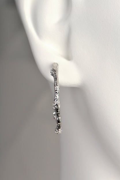 special and different large silver hoop earrings from Spanish jewellery designer Jorge Revilla that have a texture inspired by lava