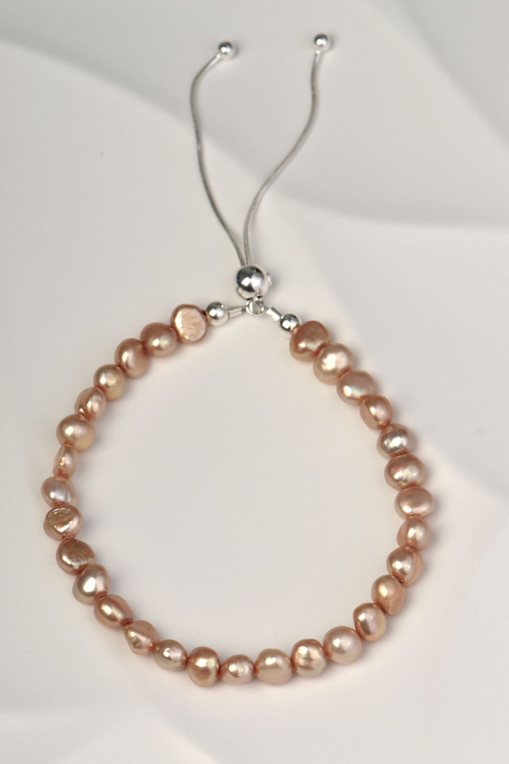 pale brown cultured pearl bracelet with a sliding silver clasp that is adjustable to fit any wrist size and easy to put on and off. 