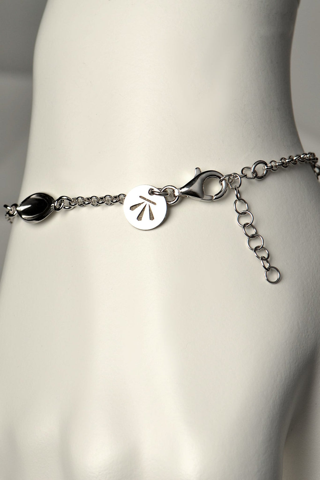modern silver charm bracelet with Christine Sadler's benchmark logo