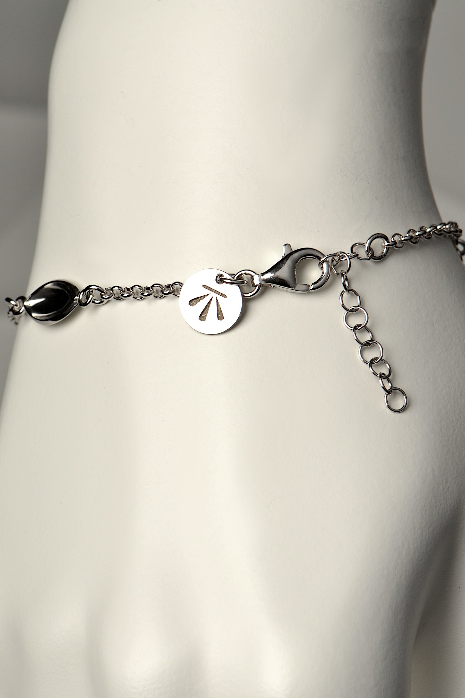 modern silver charm bracelet with Christine Sadler's benchmark logo