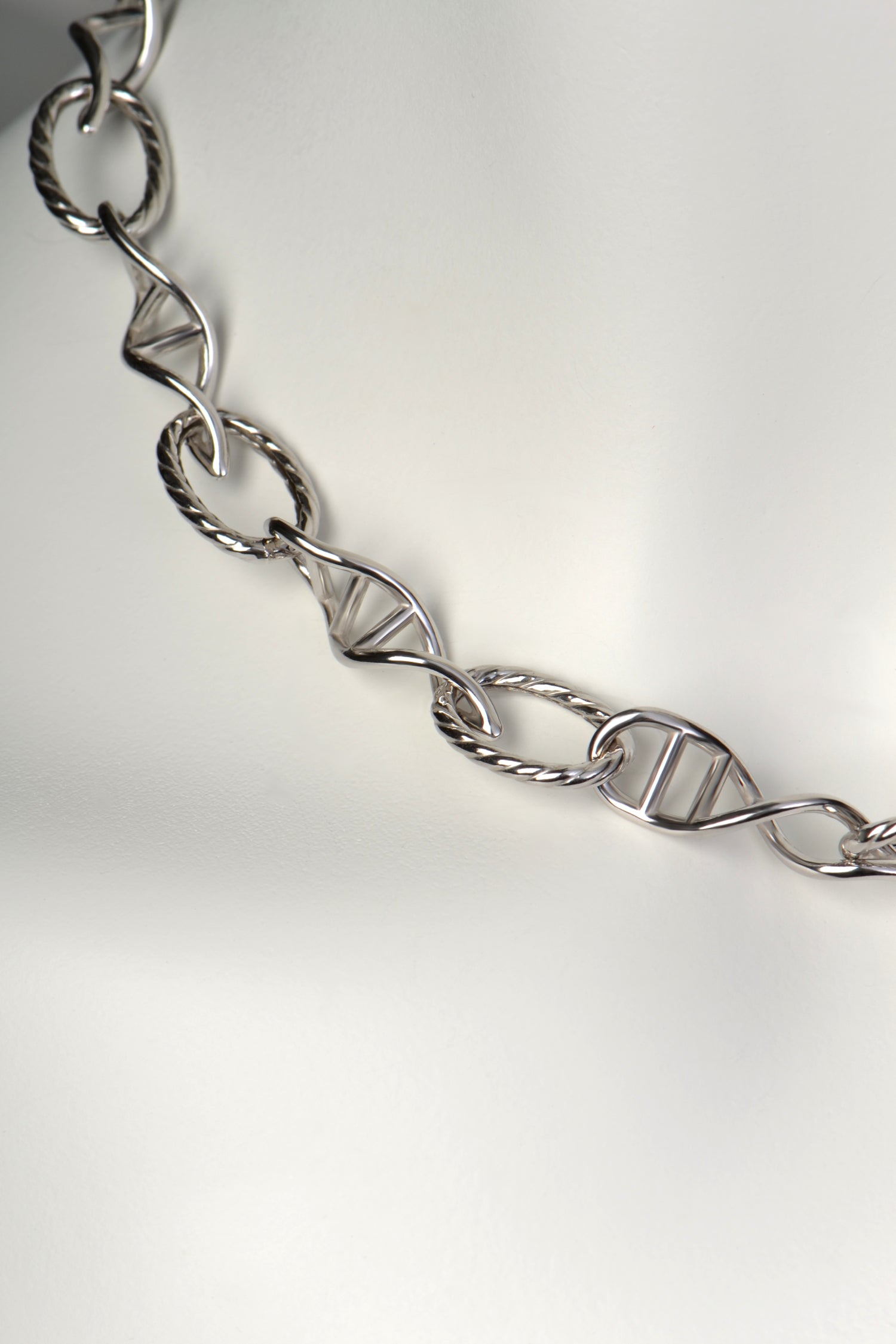 Detail of sculptural DNA double helix link in sterling silver, symbolising invisible human connection.