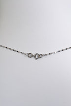 detail showing a small round bolt ring clasp on this delicate platinum chain