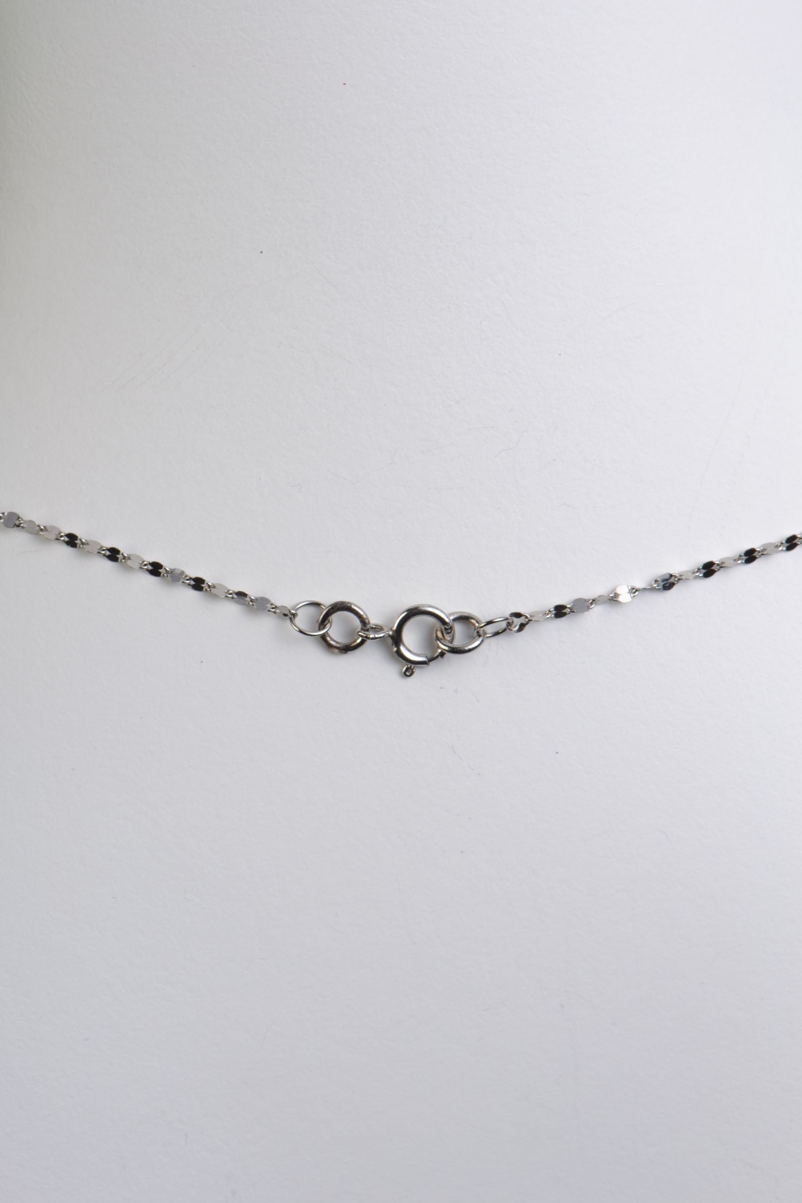 detail showing a small round bolt ring clasp on this delicate platinum chain