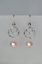 Handmade sterling silver circle earrings with pink cultured on a gray background