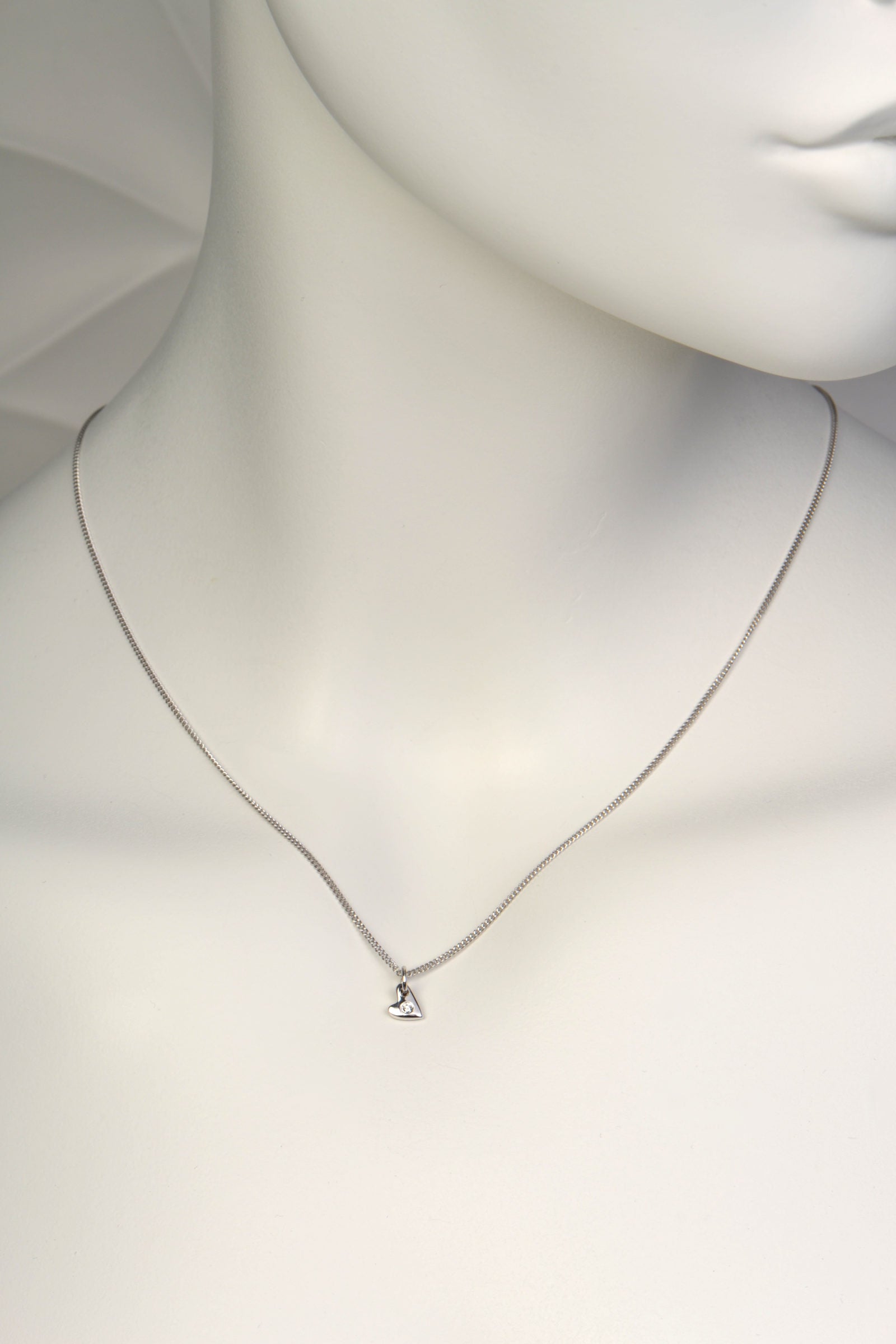 Delicate white gold heart necklace with diamond on mannequin to show scale- Christine Sadler