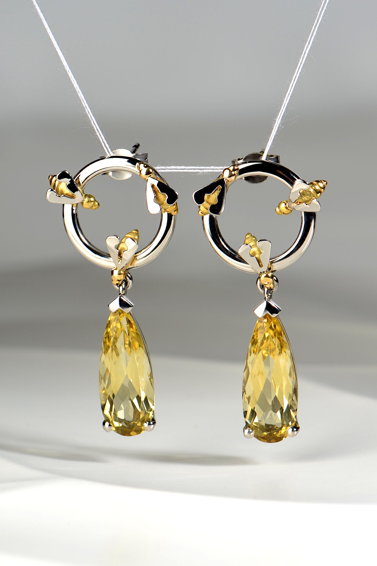 luxury fine jewellery platinum earrings that are one of a kind with long pear cut yellow beryl gemstones to look like dripping honey by contemporary jewellery designer Christine Sadler
