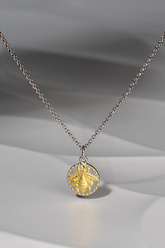 small circular pendant with a gold vermeil bee design on a silver chain - Jorge Revilla jewellery designer