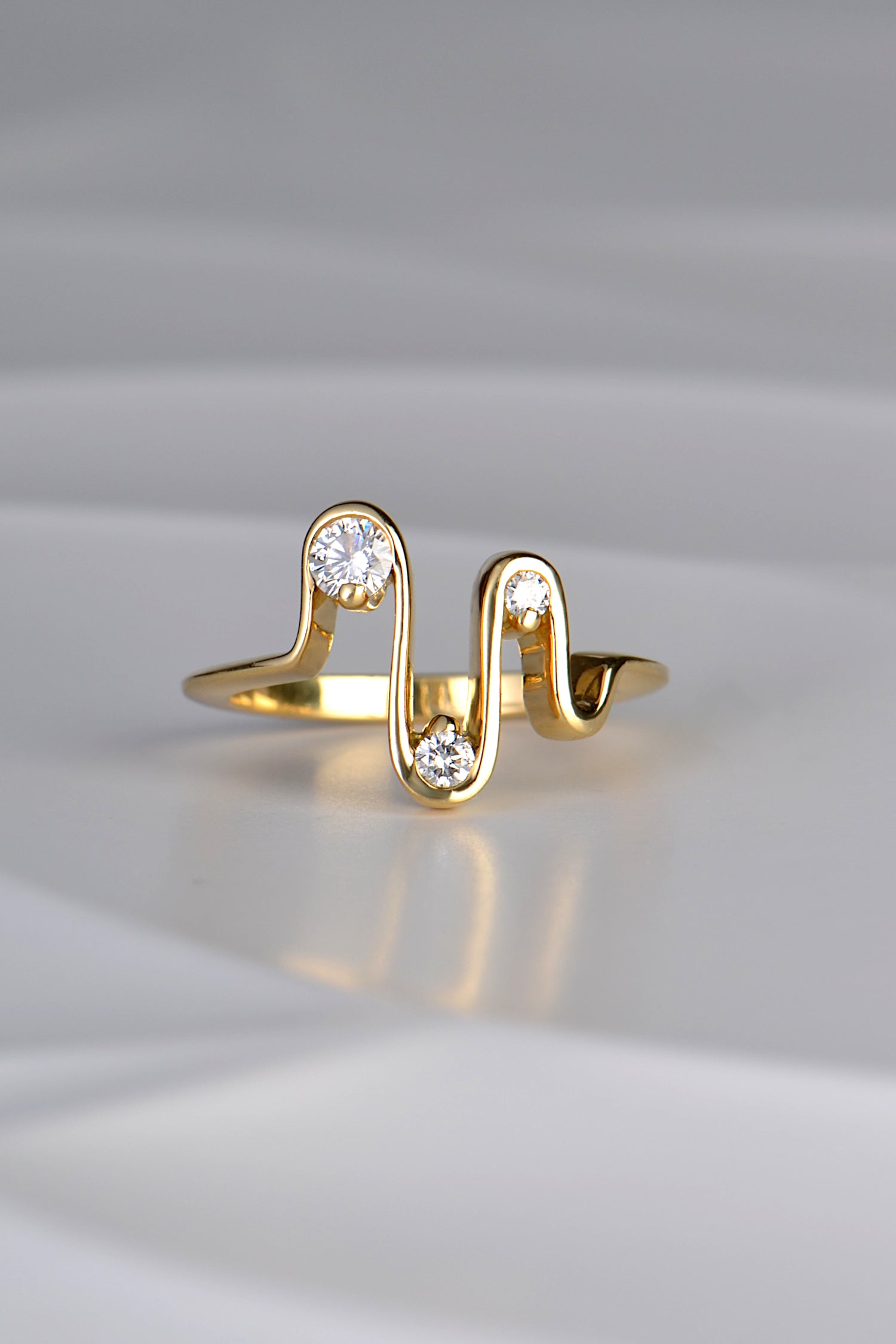 an 18ct yellow gold wavy ring with four waves and three diamonds inspired by a heartbeat