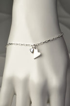 Two-heart silver bracelet worn on wrist, showing elegant modern design and meaningful pairing of brushed and polished hearts