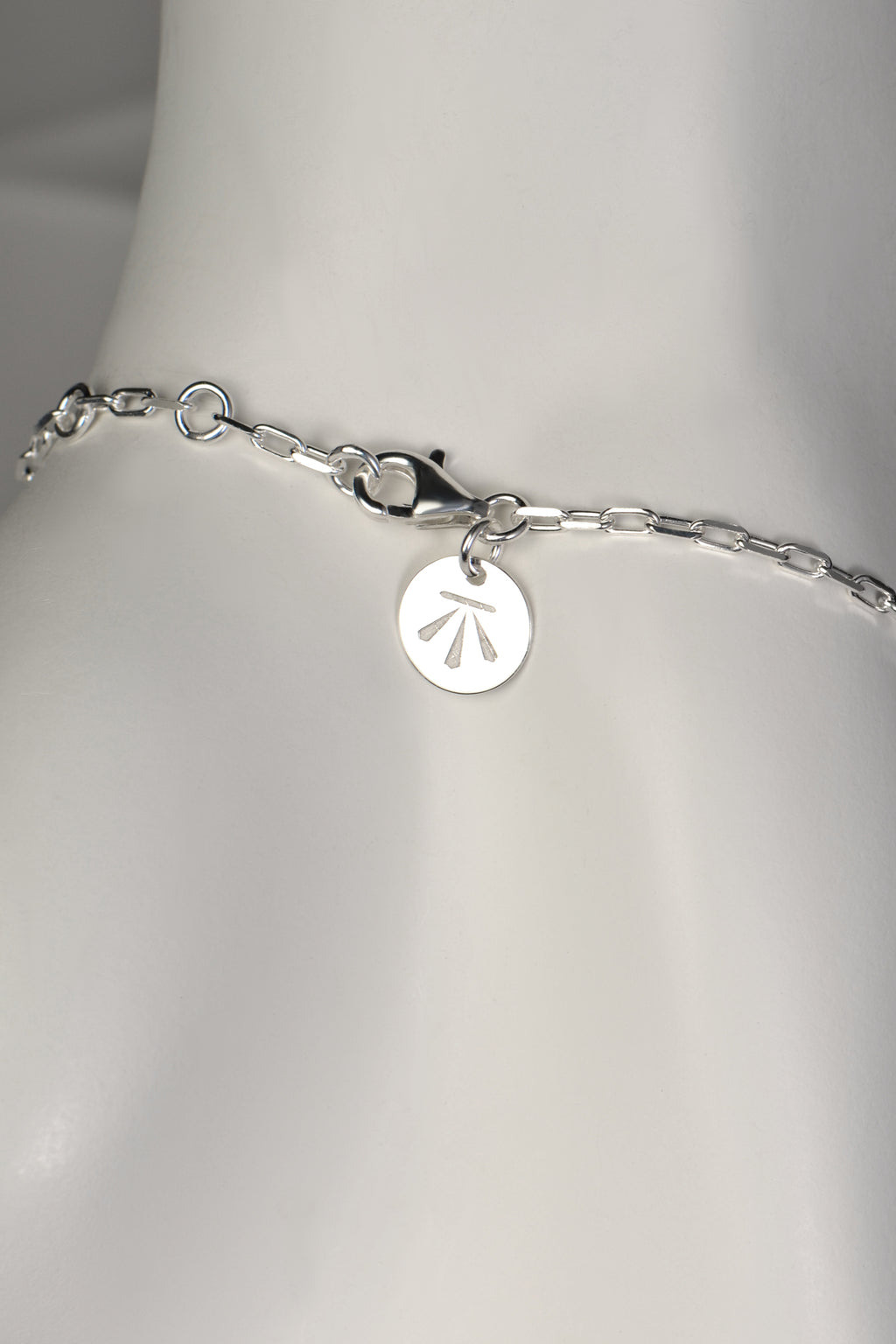 modern real silver designer bracelet that can be adjusted in length showing strong clasp with designer Christine Sadler's logo tag