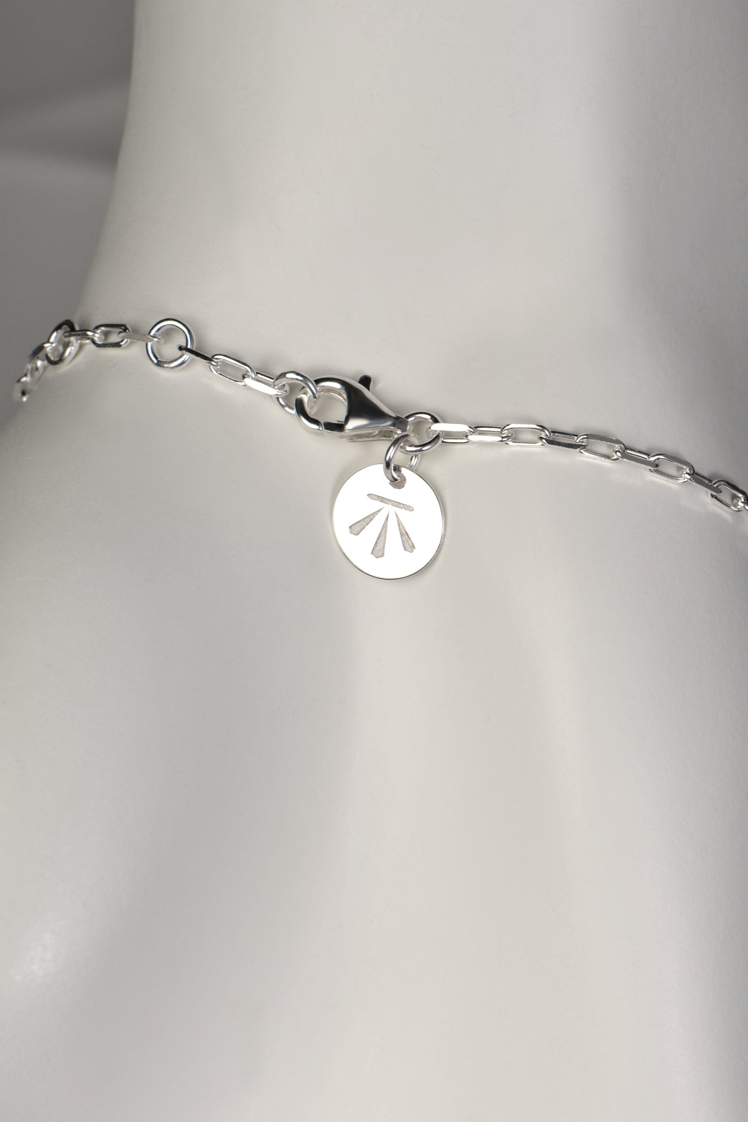modern real silver designer bracelet that can be adjusted in length showing strong clasp with designer Christine Sadler's logo tag
