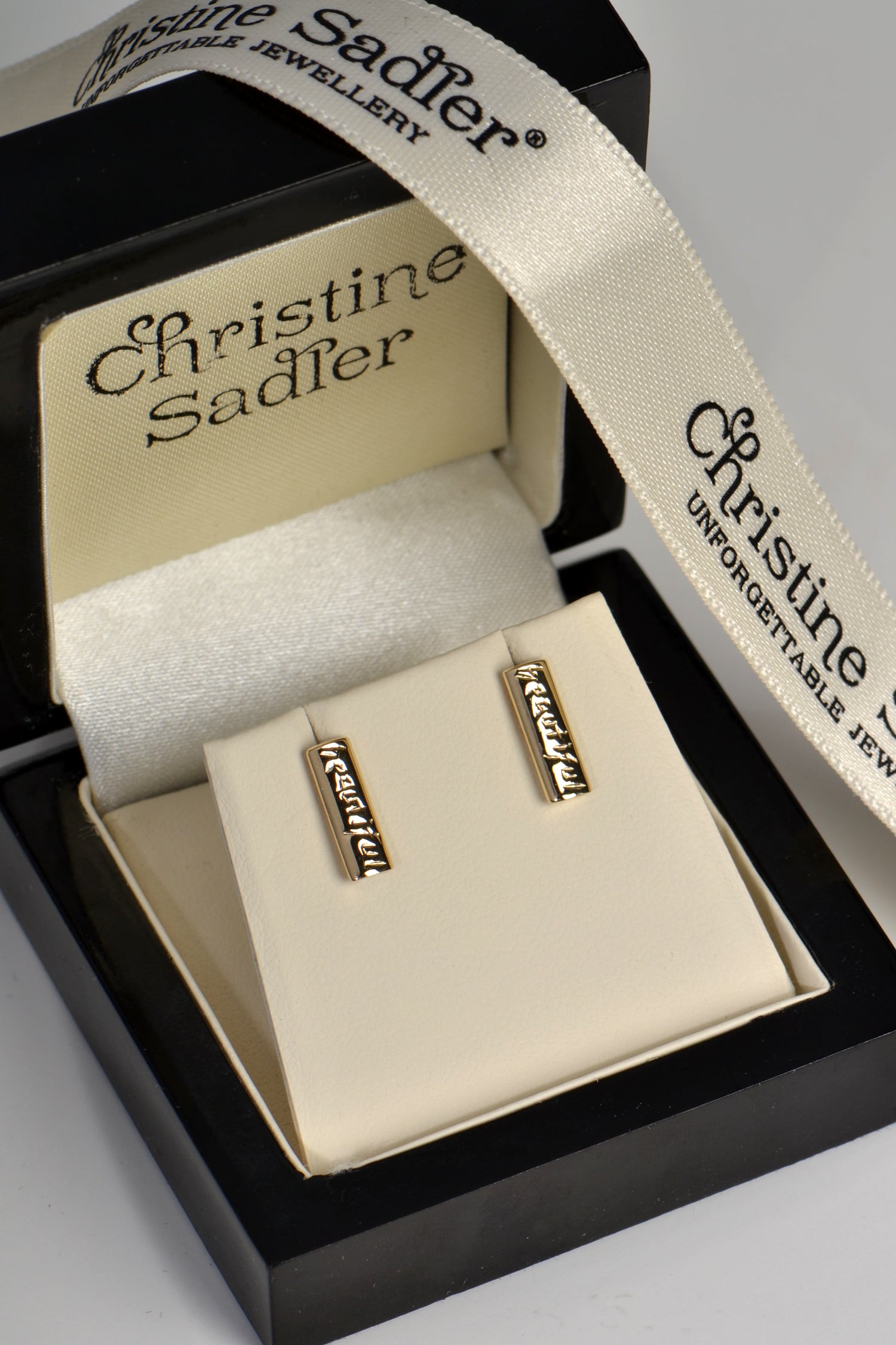 Handmade yellow gold rectangular earrings engraved on both sides with the word “beautiful”