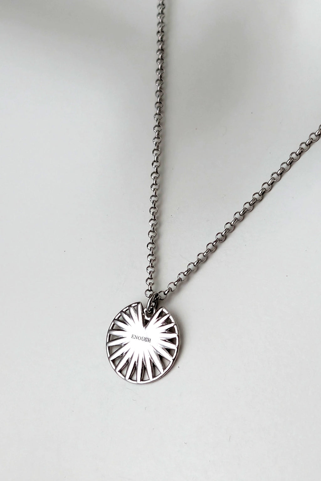 Silver disc talisman pendant necklace engraved with the word Enough