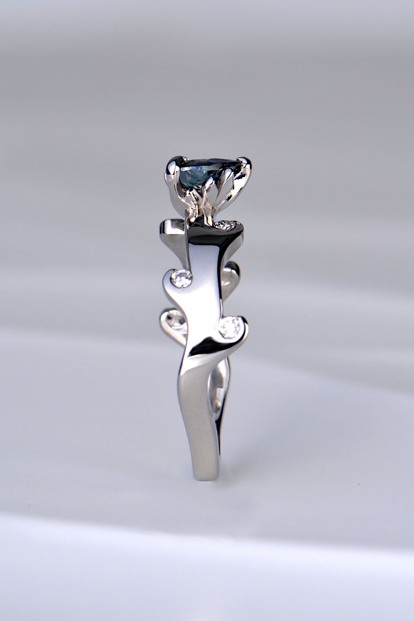 the copyrighted fire ring design by Christine Sadler that has tiny flames that lick up towards the gemstone which has tiny flames around a heart cut real alexandrite gemstone which form the setting for it. 
