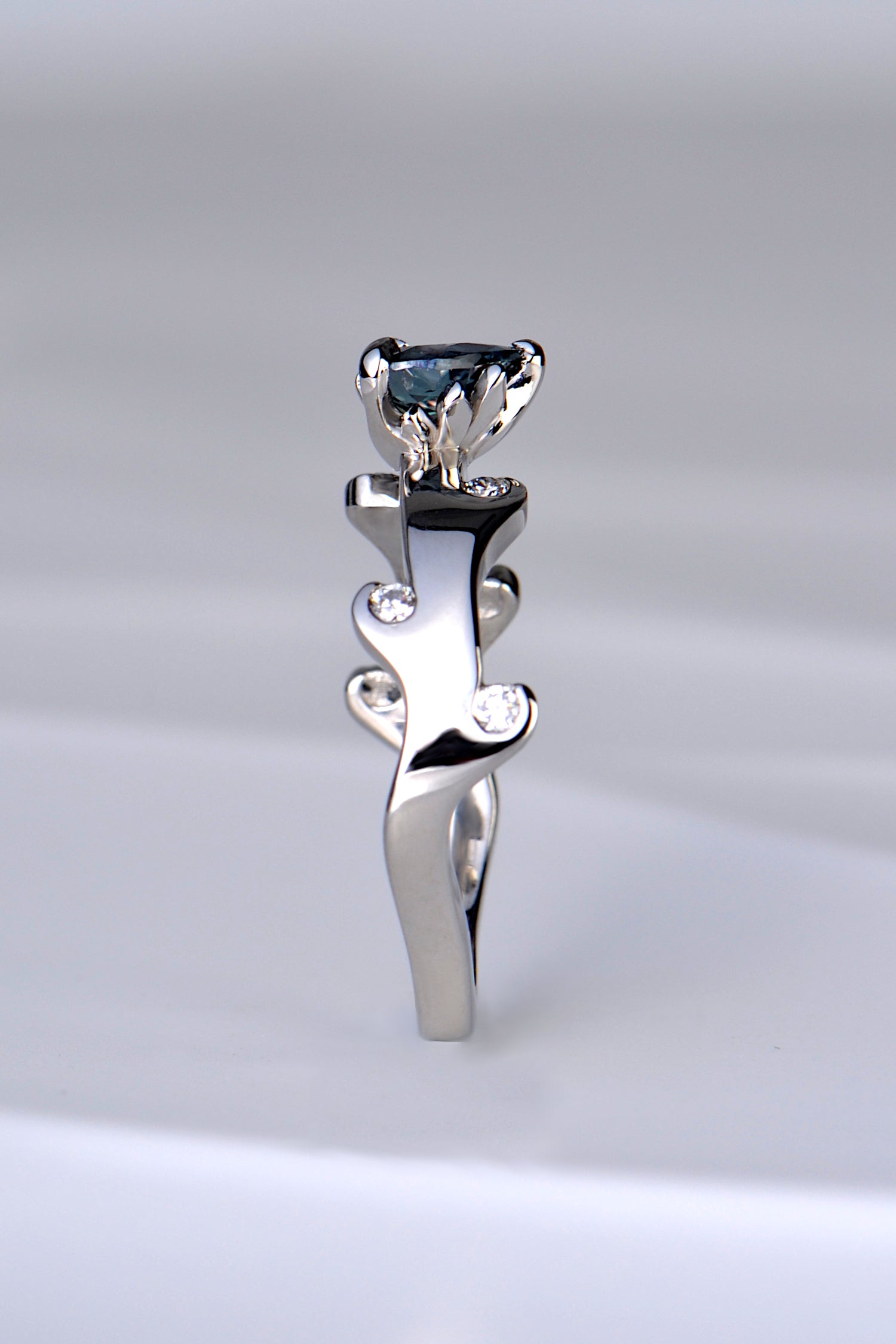 the copyrighted fire ring design by Christine Sadler that has tiny flames that lick up towards the gemstone which has tiny flames around a heart cut real alexandrite gemstone which form the setting for it. 