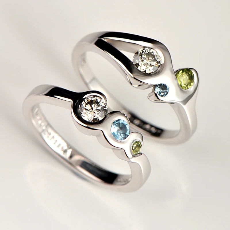 diamond, peridot and aquamarine white gold engagement rings set with the couple's birthstones in a fire and water design - Christine Sadler