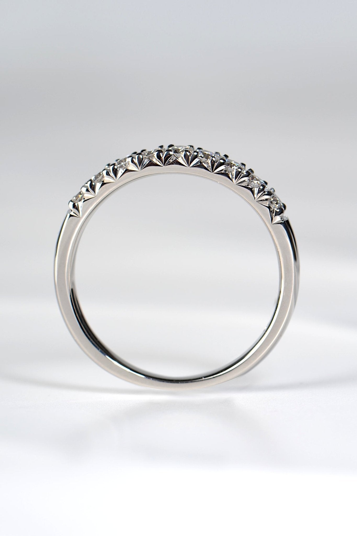 Side view of a platinum fishtail diamond band showing the heart-shaped setting detail