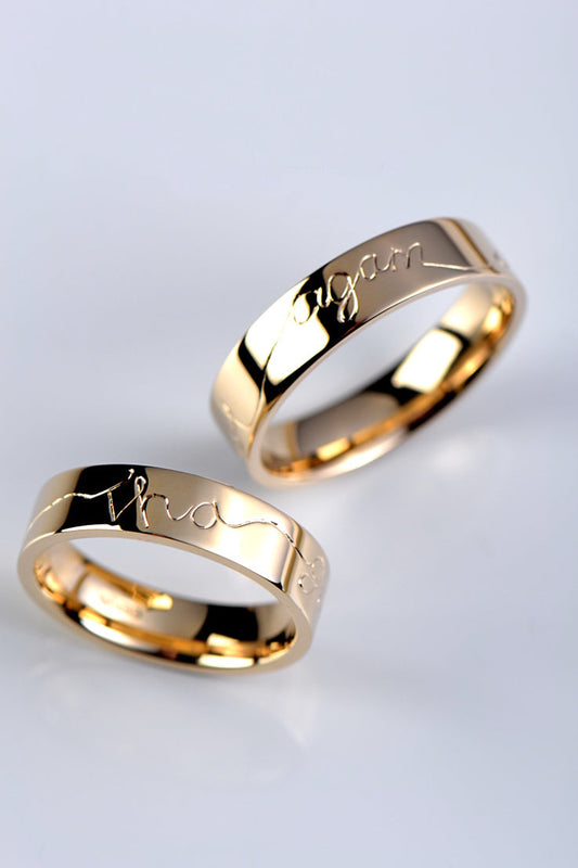 a set of yellow gold wedding rings with gaelic engraving