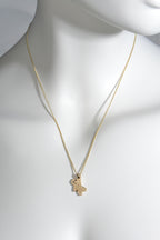 adorable delicate gold necklace in the shape of a tiny gingerbread man with black diamond eyes hanging from a gold curb chain. Designer Christine Sadler