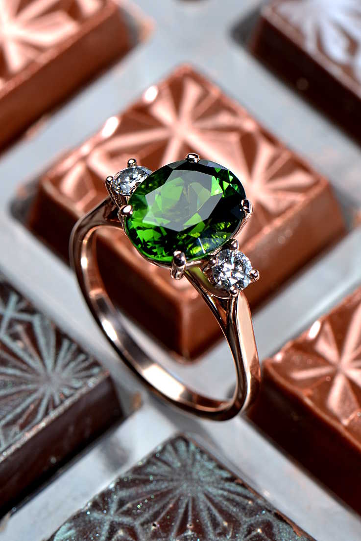 rose gold ring with an oval green chrome tourmaline gemstone and a round white diamond on either side - one-of-a-kind Christine Sadler engagement ring