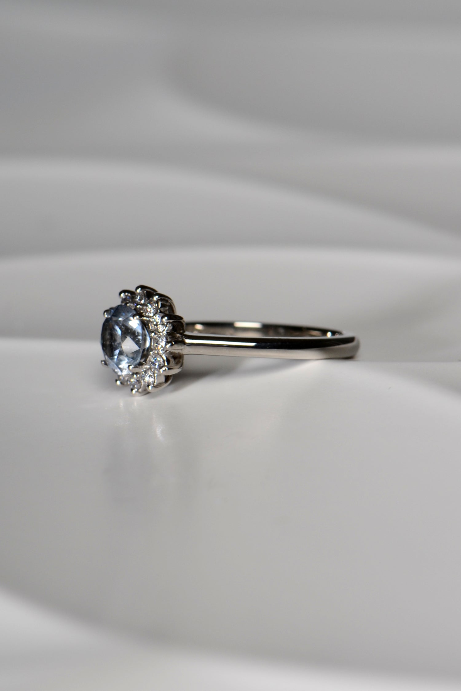platinum engagement ring with a central grey sapphire surrounded by white diamonds in a flower shape - a one-of-a-kind engagement ring from Christine Sadler called Moonflower