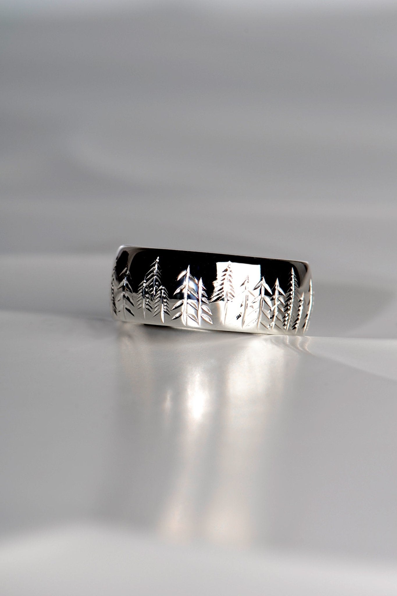 Platinum ring with trees hand engraved on it for a man or woman