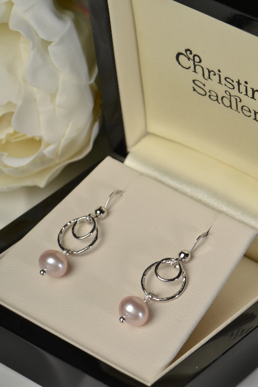 Sterling silver earrings with pink cultured pearls in a Christine Sadler box.