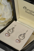 Sterling silver earrings with pink cultured pearls in a Christine Sadler box.