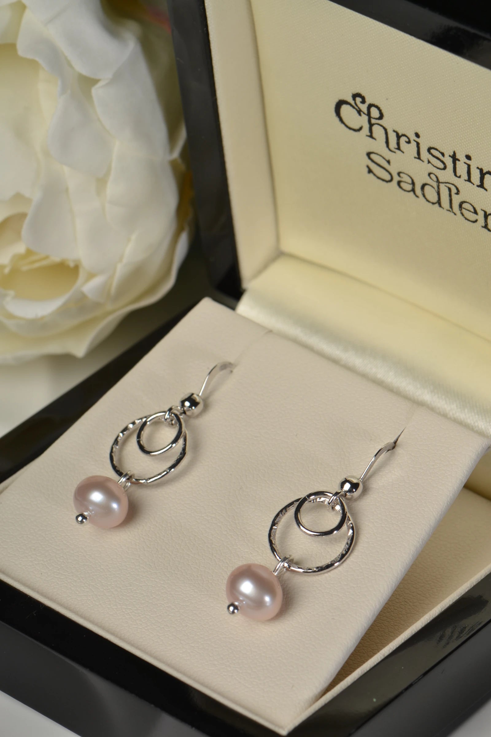 Sterling silver earrings with pink cultured pearls in a Christine Sadler box.