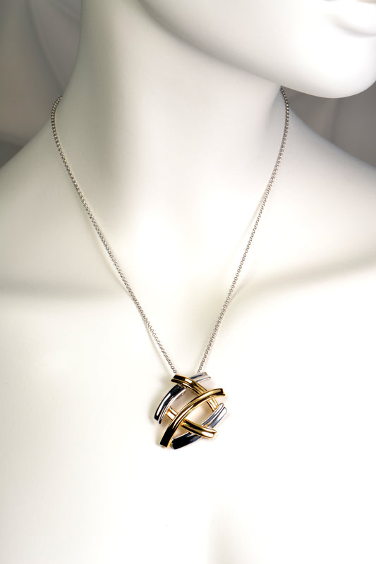 five criss cross bands create a pendant that looks like several large silver and gold kisses. The necklace in silver with gold vermeil.
