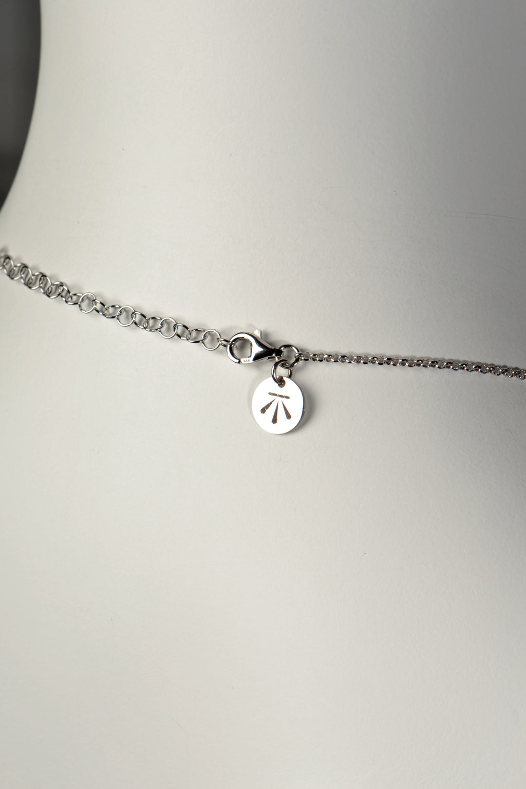 close up detail of extendable chain with Christine Sadler's benchmark logo