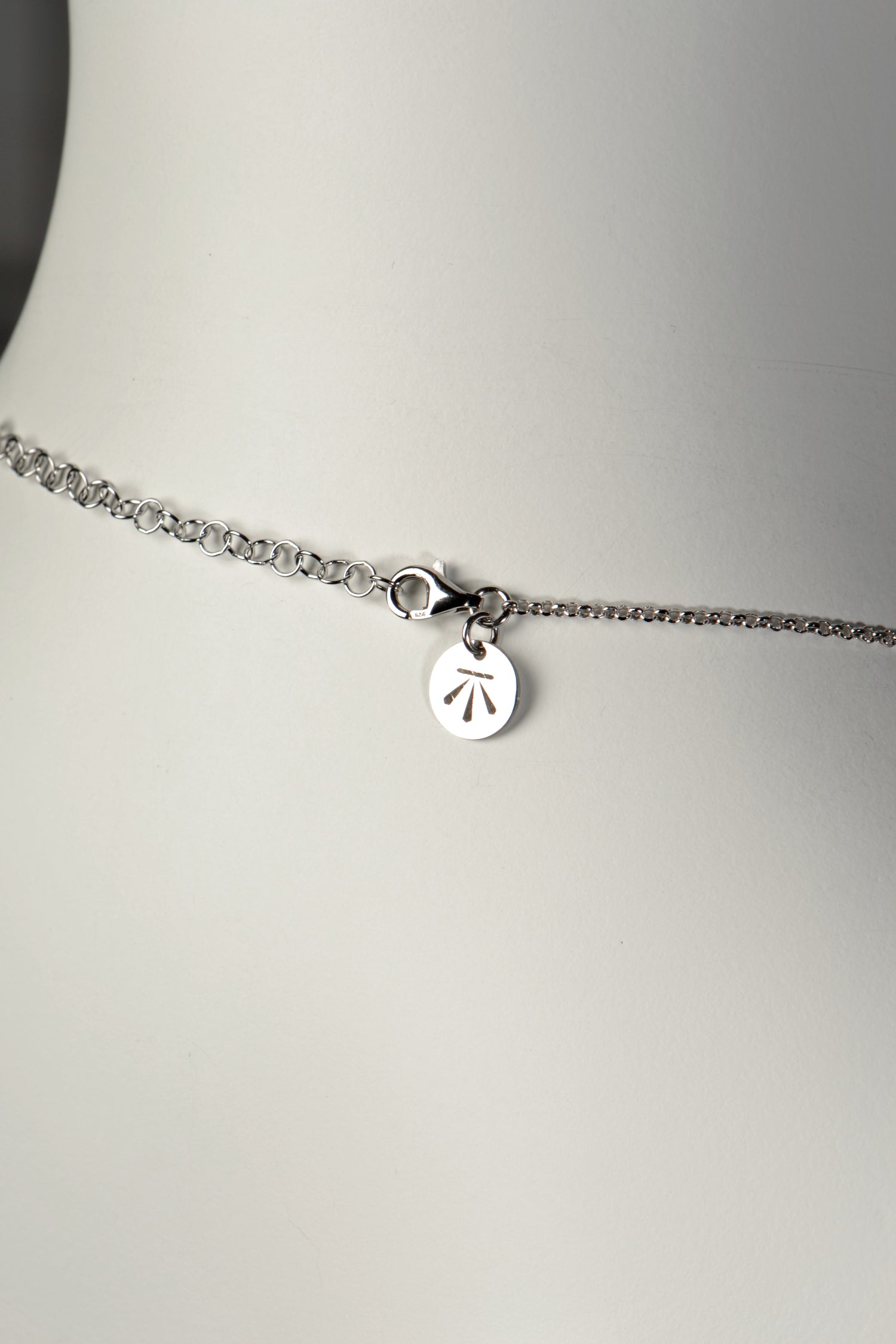 close up detail of extendable chain with Christine Sadler's benchmark logo