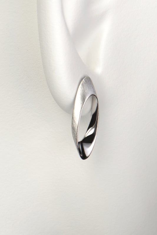 long oval designer silver stud earring that sits on the lobe and drops down below it. 