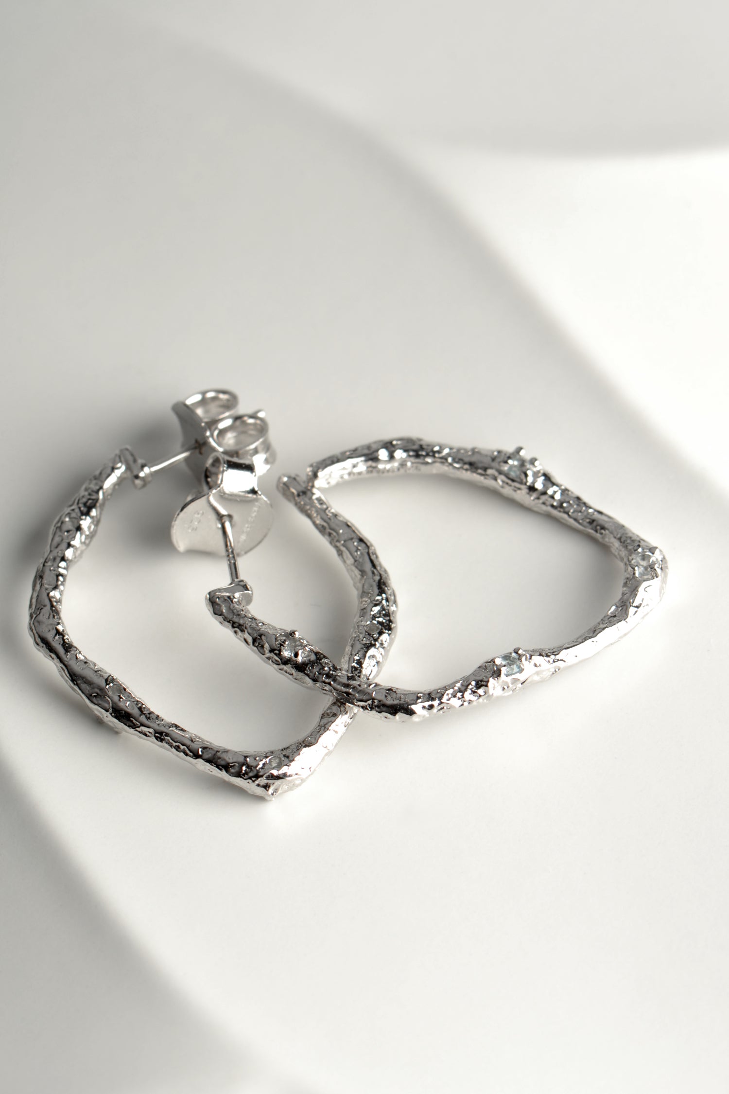modern large silver hoop earrings that are really special from jewellery designer Jorge Revilla. These earrings have a texture that looks like molten metal and the jewellery collection is called Lava