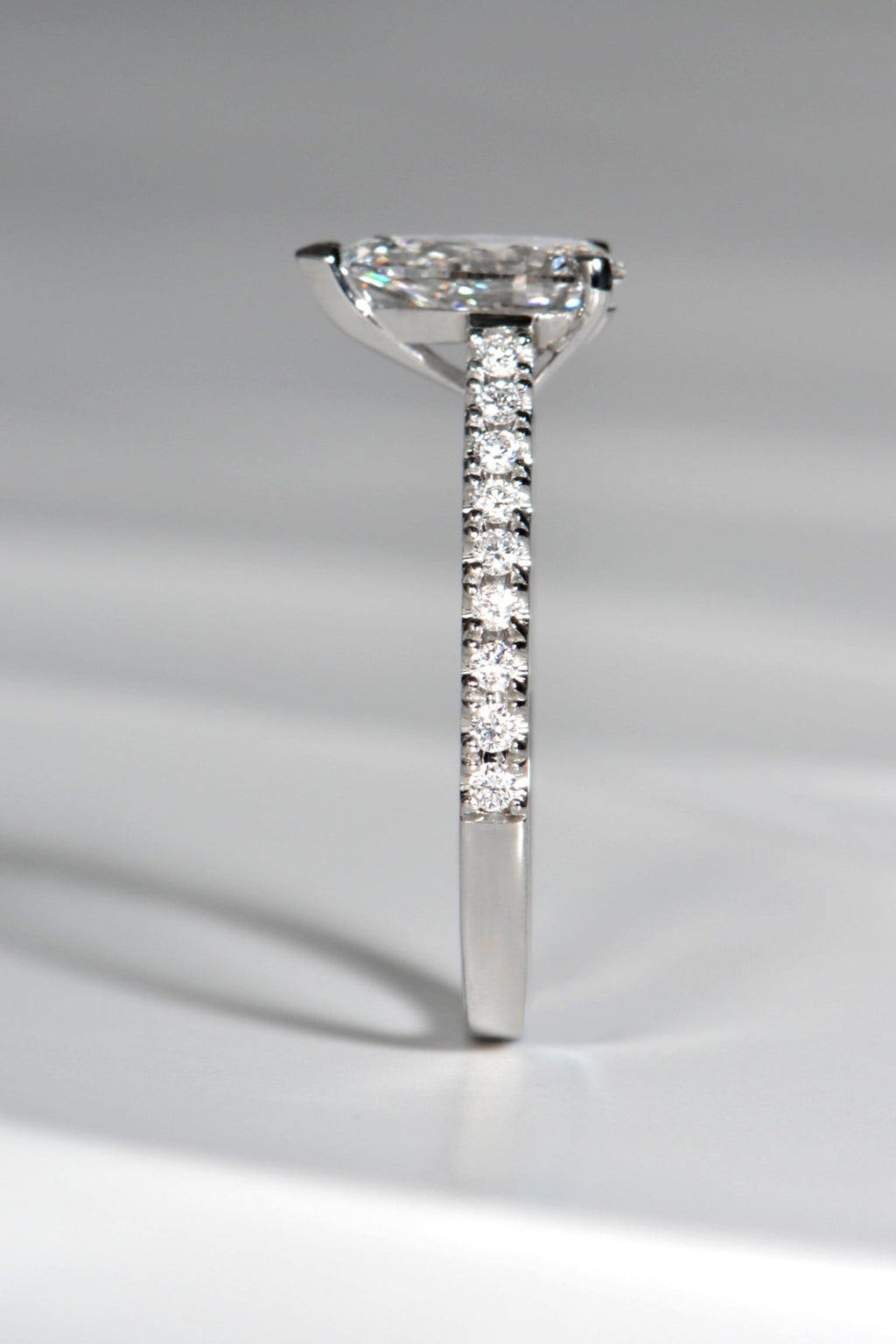 side view of modern pear cut diamond ring that is set high so a wedding ring can sit next to it. Available in lab grown or mined diamonds