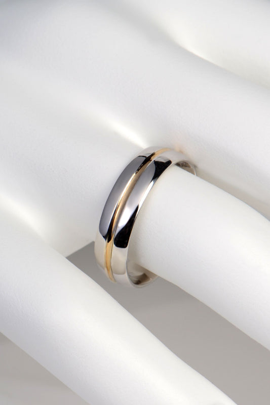 Handcrafted 9ct white and yellow gold wedding ring, court shaped comfort fit design shown on a finger