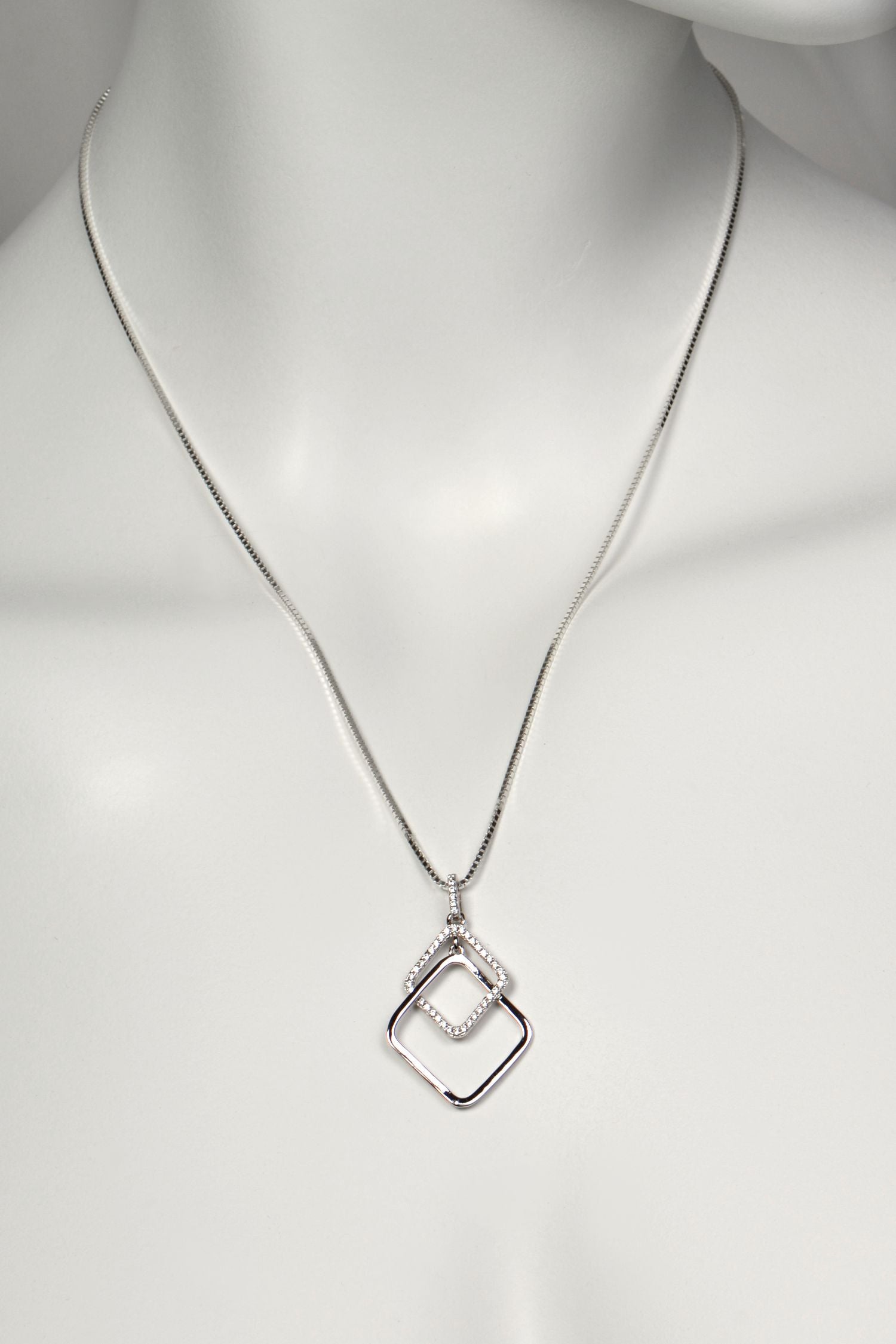 Silver sparkly necklace with a geometric pendant on a mannequin against a white background