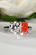 Face-on view of a platinum Moi et Toi ring featuring a radiant cut vivid pink lab diamond and a round white diamond against a white rose background, by Christine Sadler