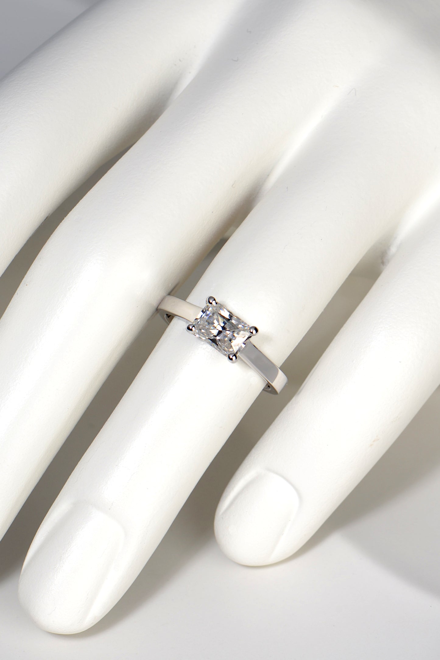 designer moissanite white gold ring on a finger to see how big it looks. It covers approximately half the finger with a quarter of the ring visible on either side of it. It looks impressive in size. 
